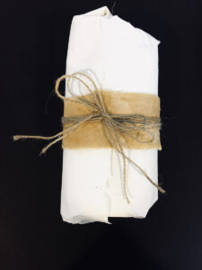 A parcel wrapped in paper, fabric and twine.