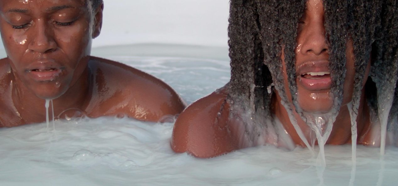 Artist, Corinne Spencer's work. Two people sitting in what appears to be a bathtub with shoulders and up emerged from water