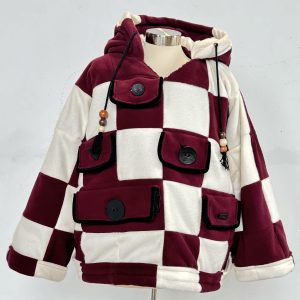 a marron and white patchwork hoodie made with square patterns to make up this hoodie that is displayed on a dress form in front of a white wall